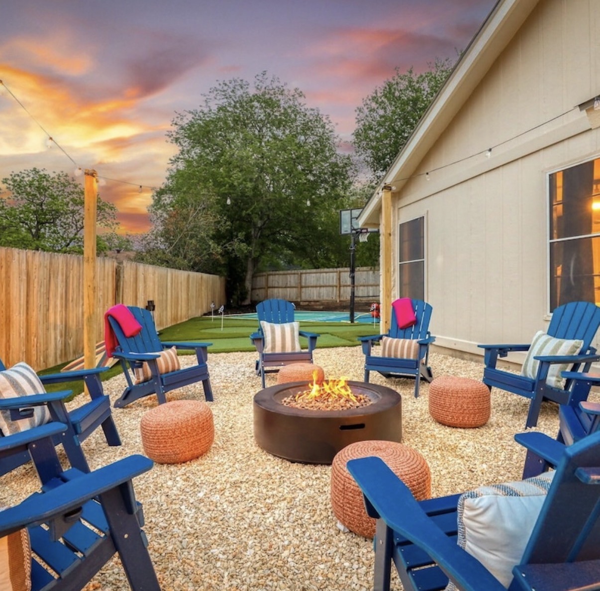 Fire-pit lounge at sunset, with the courts and putting green beyond